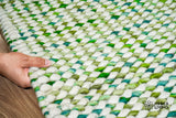Cashew Loop — Green wool rug shown flat and in full on a plain white ground, detail crop of the centre (first pass)