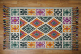 Close-up of handwoven texture on green wool rug