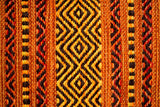 Orange kilim rug placed by bedside