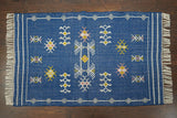 Blue kilim rug styled in a bohemian bedroom