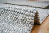 Grey wool rug styled in Scandinavian living room