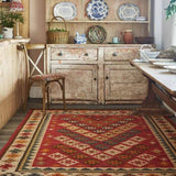 Red Aztec kilim rug laid flat showing full geometric pattern