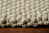 Grey wool rug styled in a living room