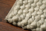 Grey wool rug pile texture close-up in natural light