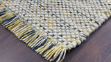 Full view of multi blend chunky wool rug on wood floor