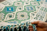 Sage green wool rug placed in bedroom setting