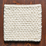 Ivory loop chunky wool rug in bedroom setting