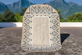 Beige oval rug styled on a patio