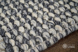 Grey wool rug styled in a living room