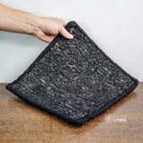 Black wool rug rolled showing thickness