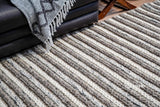 Brown grey wool rug placed in a bedroom corner