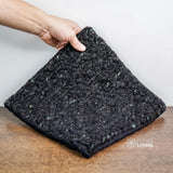 Black wool rug styled in a Scandinavian living room