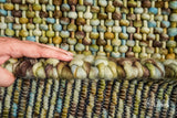 Green wool rug styled with furniture in room