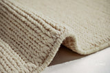 Close-up of ivory wool rug braided knit texture