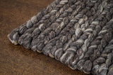 Charcoal grey braided wool rug styled in a living room