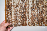 Corner detail of ivory brown textured wool rug