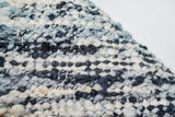 Corner detail of ivory blue textured wool rug