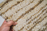Ivory beige striped wool rug styled in a living room