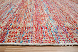 Multi blend red chevron flatweave rug in a bedroom setting