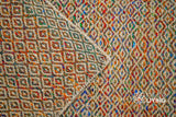 Multi blend diamond flatweave rug in a bedroom setting