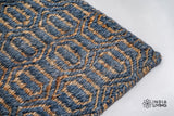 Handwoven diamond weave rug shown in a bedroom setting