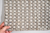 Beige cream wool rug in a Scandinavian bedroom