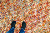 Multi blend orange wool rug styled in a living room