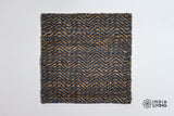 Handwoven herringbone rug shown in a bedroom setting
