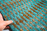 Close-up of ribbed geometric weave texture on turquoise jute wool rug
