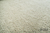 Beige wool rug shown under a coffee table