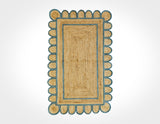 Scalloped jute rug with aqua blue border, flat lay view