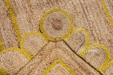 Yellow jute runner edge close-up highlighting scallop stitching