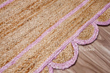 Light pink scalloped jute runner styled beside furniture in a living room