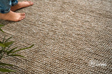 Beige wool rug edge close-up highlighting bubble weave pattern