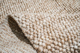 Detail shot of wool fiber texture on beige rug