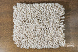 Corner view of taupe grey wool shag rug showing pile depth