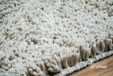 Taupe grey wool shag rug styled in a bedroom setting
