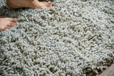 Taupe grey wool shag rug folded to show thickness and texture