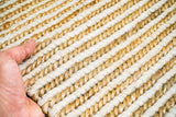 Corner view of wool jute braid rug on wooden floor