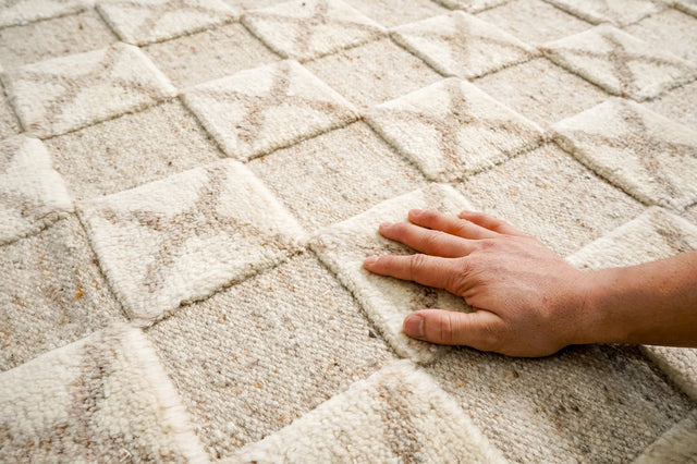 Detail of a hand-knotted wool rug showing the dense pile and intricate pattern made by master weavers