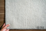 Close-up of ivory wool loop weave texture