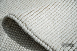 Ivory wool rug styled in a living room