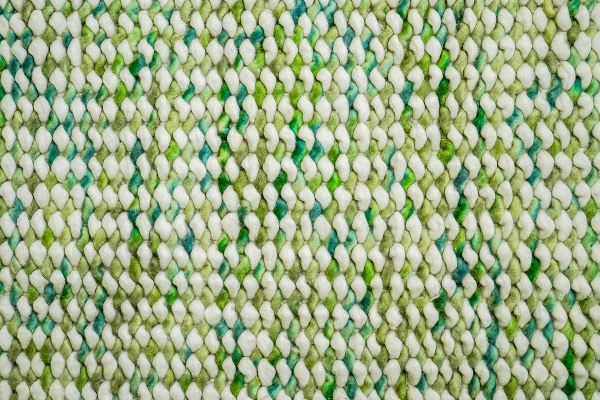 Cashew Loop — tight overhead detail of rounded ivory and green wool loops