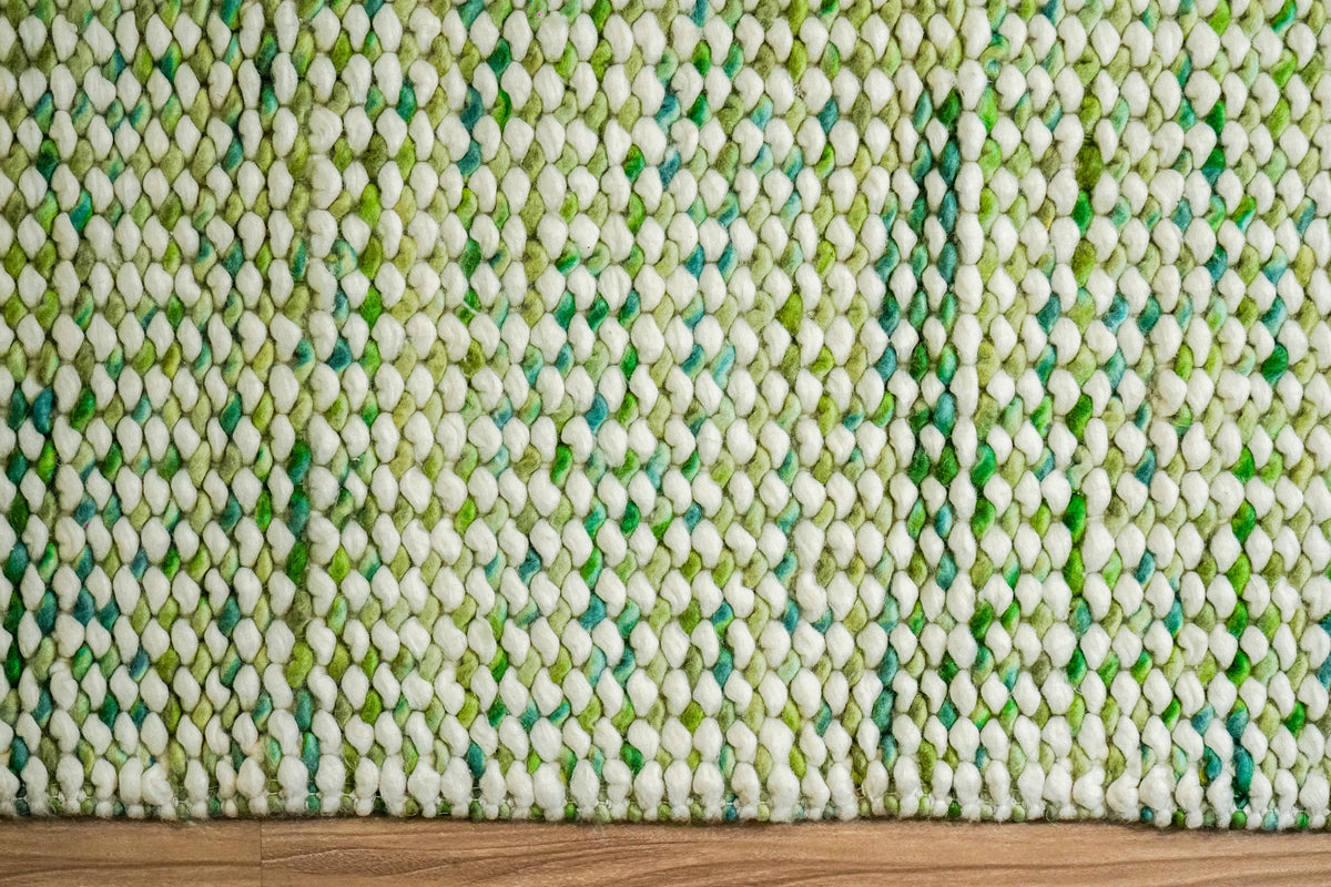 Green Cashew Loop — front section of the chunky wool loop rug showing vertical color variation and the lower edge