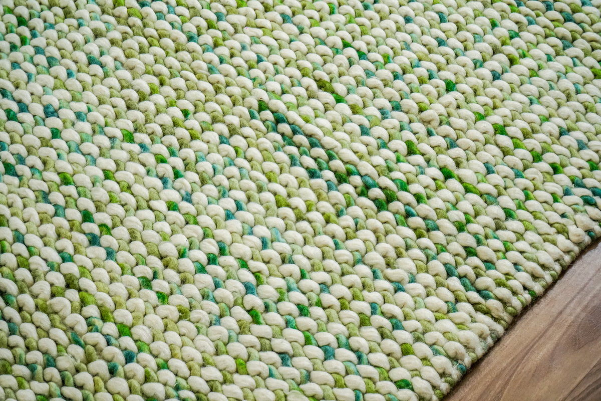 Green Cashew Loop — low angled detail showing rounded wool loops beside the diagonal right edge