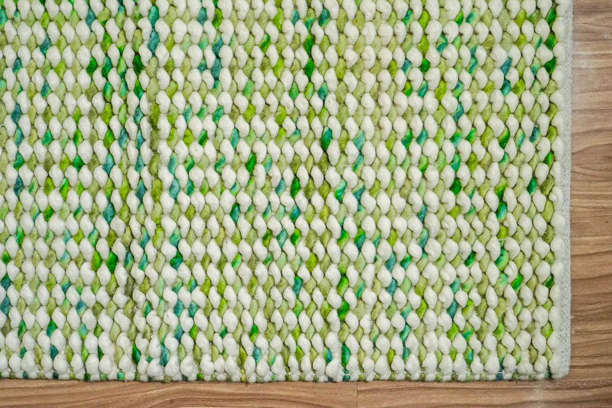 Cashew Loop — overhead corner detail showing the green and ivory loop pattern and two finished edges