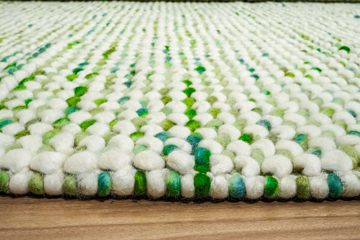 Green Cashew Loop — floor-level view of the chunky wool loops along the front edge