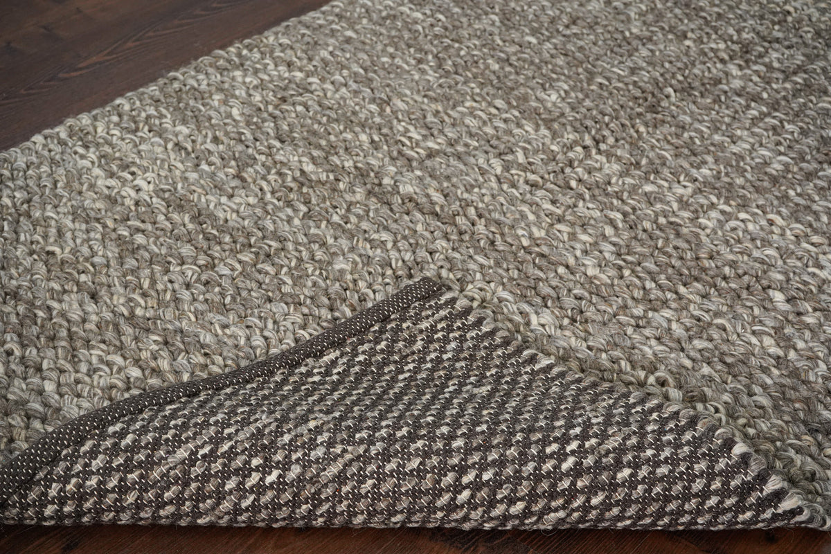 Brown Cashew Loops — wool rug in a wider view with a broad folded corner exposing the reverse construction