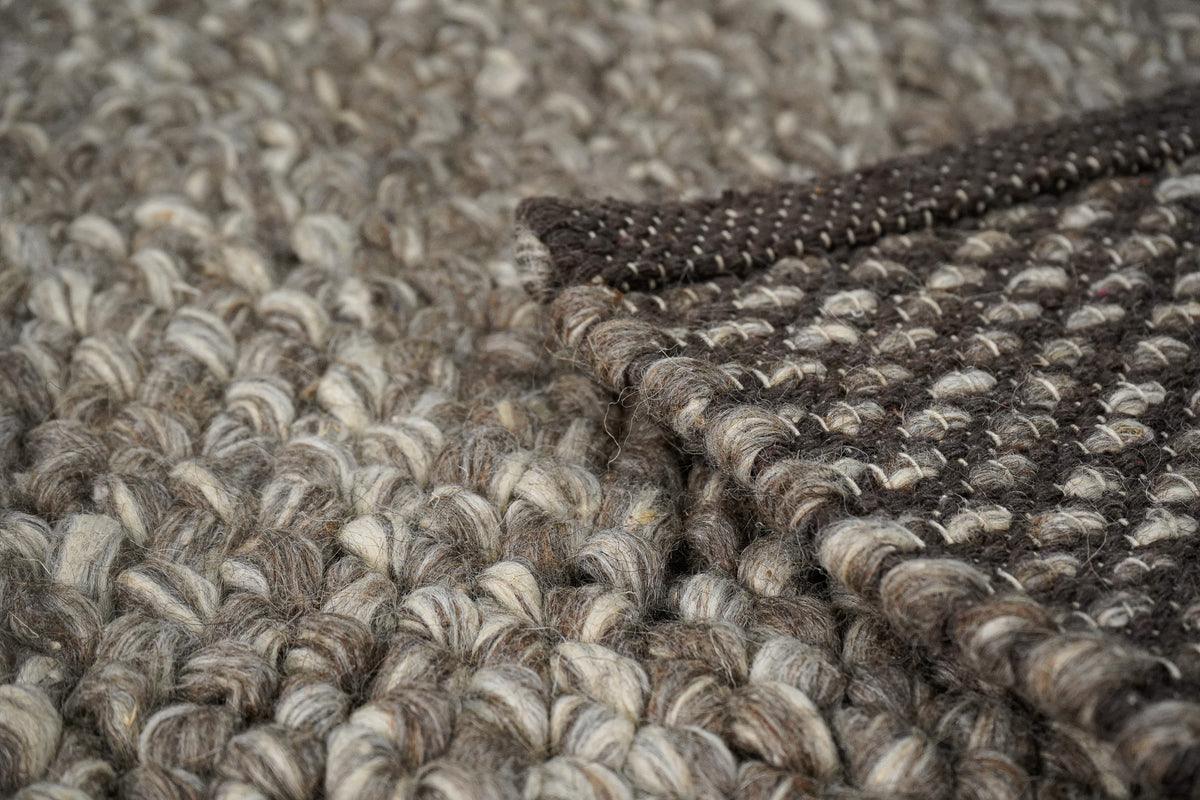 Brown Cashew Loops — wool rug showing the underside edge resting across the chunky loop surface