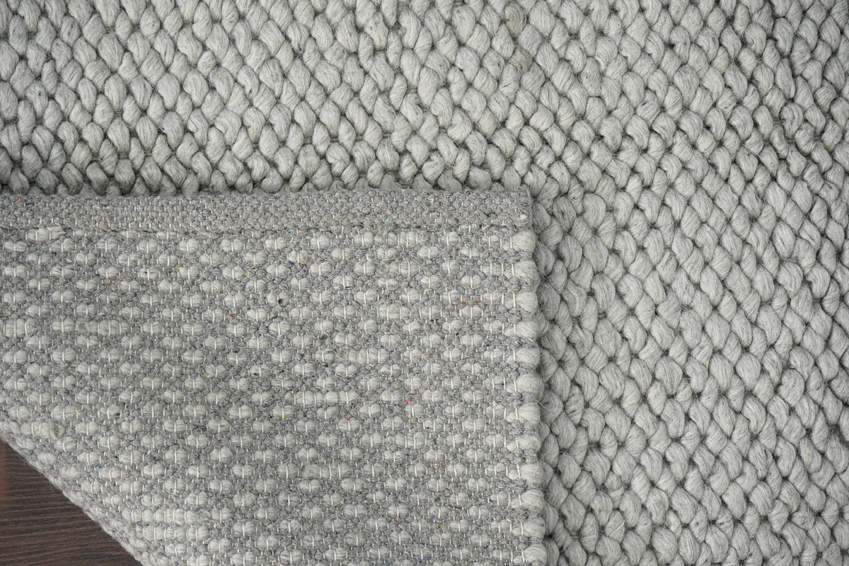 Gray Cashew Loops — wool rug with a turned corner showing the underside and bound edge